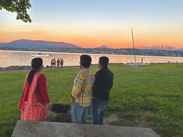 Three persons staring at sunset